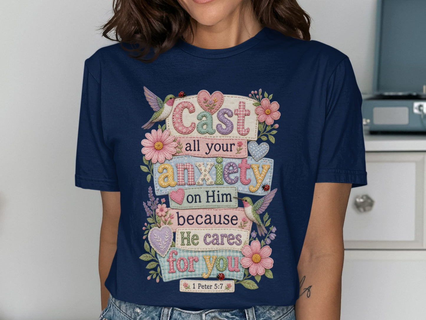 Navy t-shirt with "Cast all your anxiety on Him because He cares for you 1 Peter 5:7" and floral accents.
