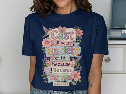 Navy t-shirt with "Cast all your anxiety on Him because He cares for you 1 Peter 5:7" and floral accents.