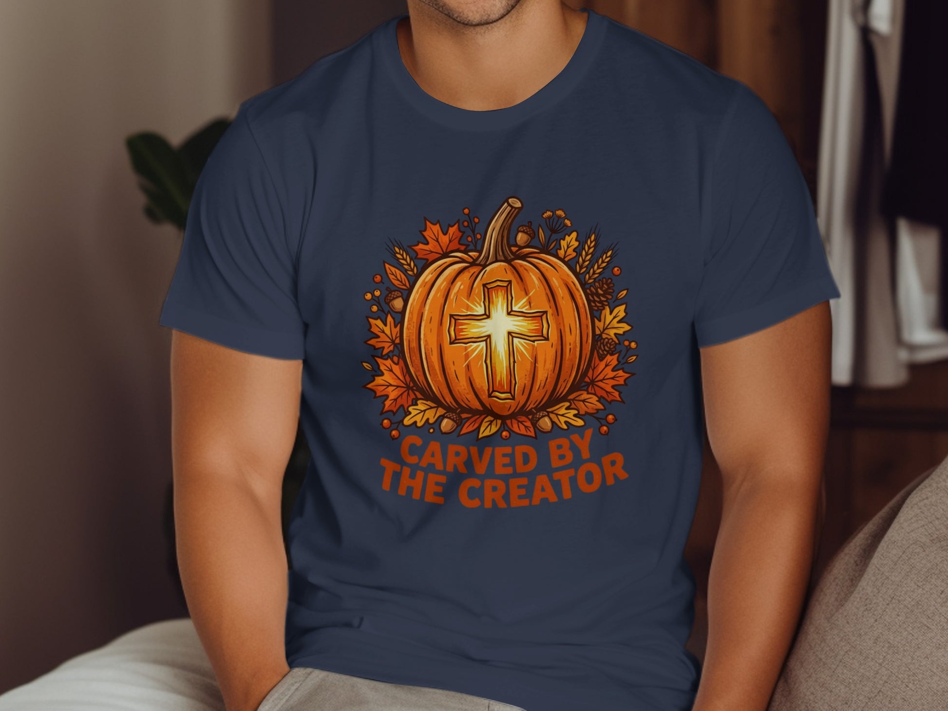 Orange pumpkin with cross carved, surrounded by autumn leaves and wheat.