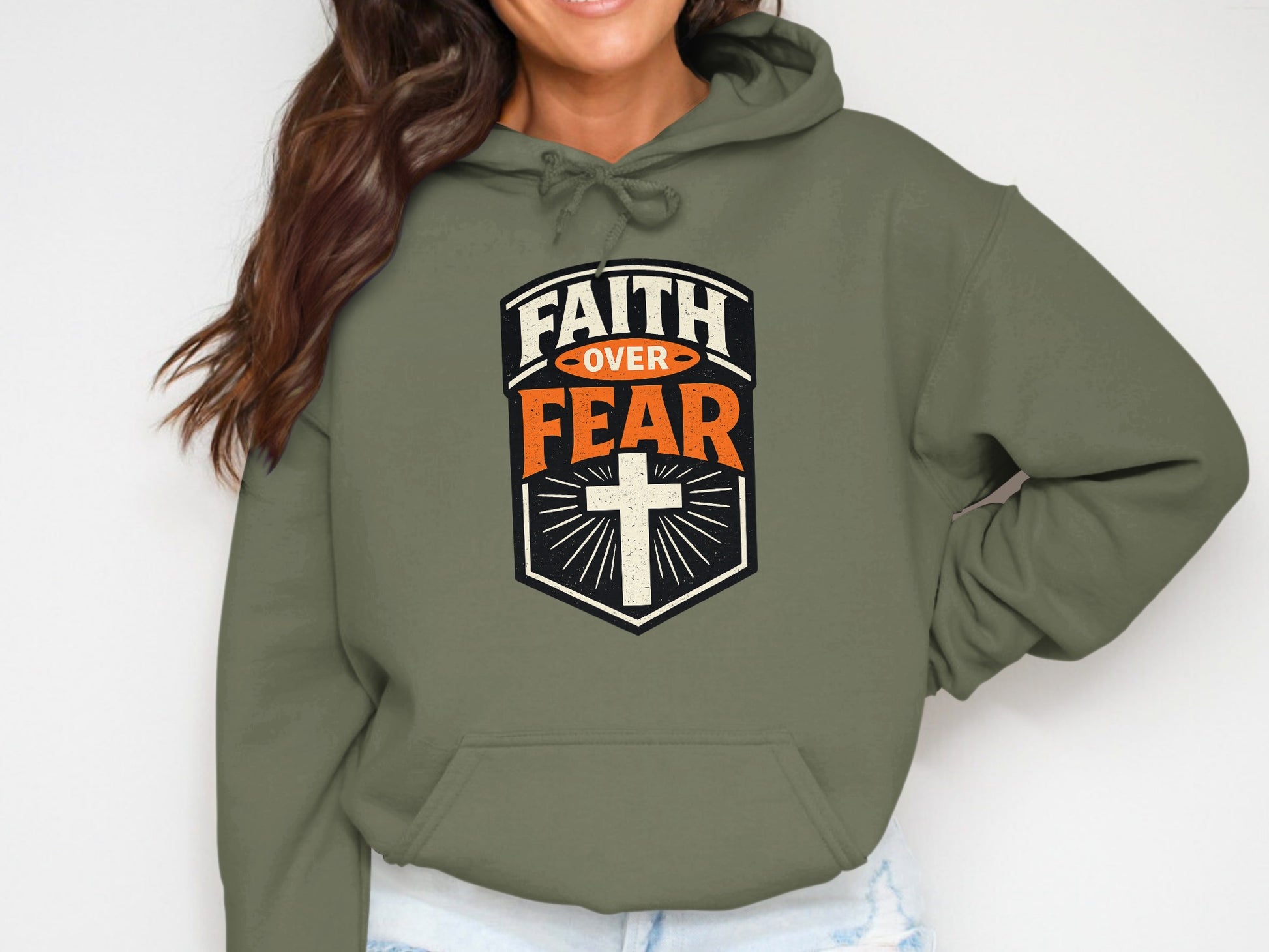 Olive green hoodie with "FAITH OVER FEAR" text and a cross.