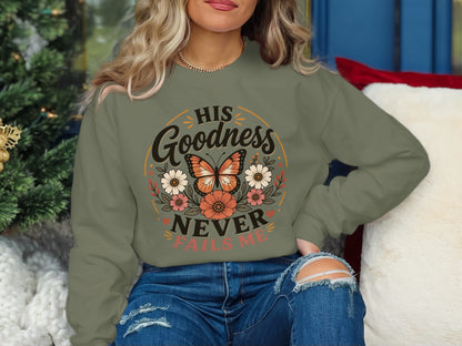 Green sweatshirt with butterfly, flowers, and text "His Goodness Never Fails Me."