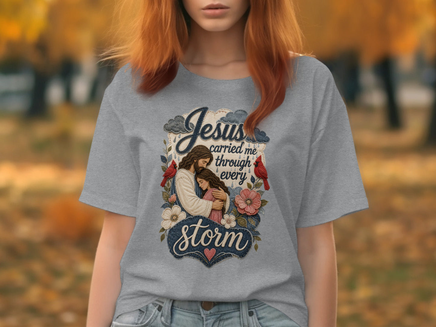 Grey t-shirt with Jesus embracing a woman, with text "Jesus carried me through every storm".