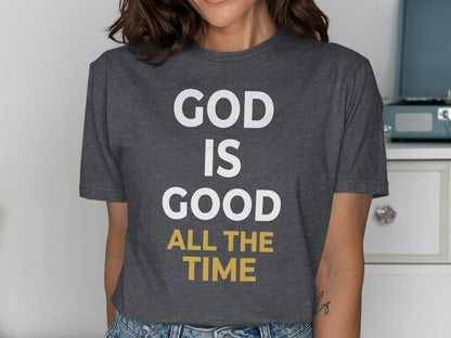 Dark grey t-shirt with white and gold text "GOD IS GOOD ALL THE TIME".