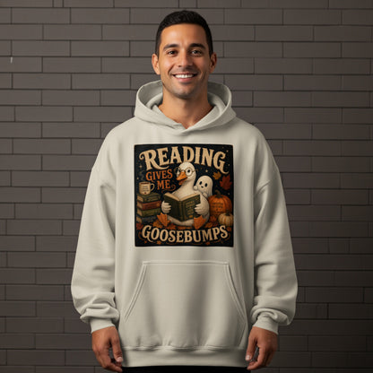 A goose wearing glasses reads a book, with a ghost and pumpkins, stating "Reading Gives Me Goosebumps."