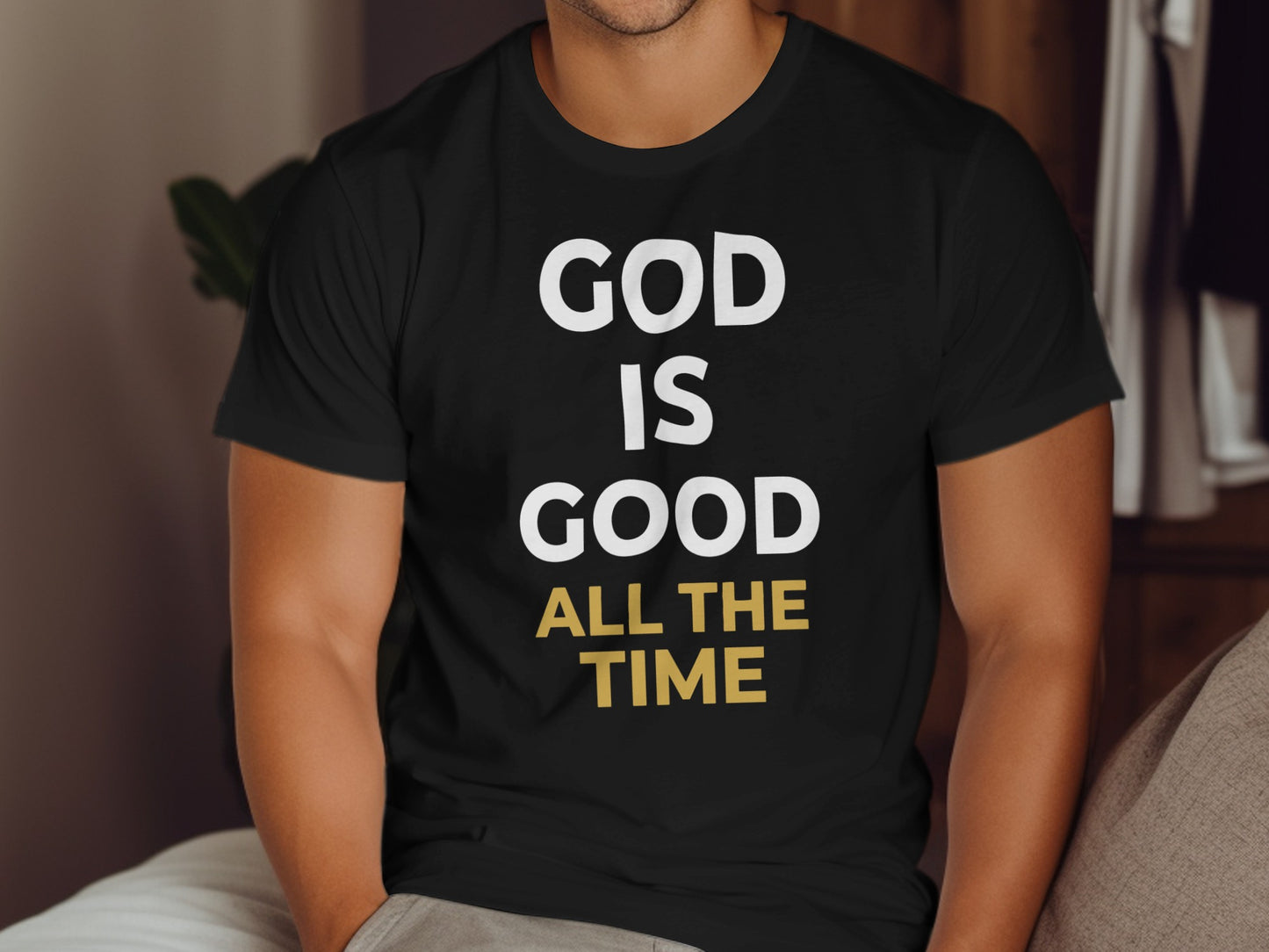 Black t-shirt with white text "GOD IS GOOD" and yellow text "ALL THE TIME".