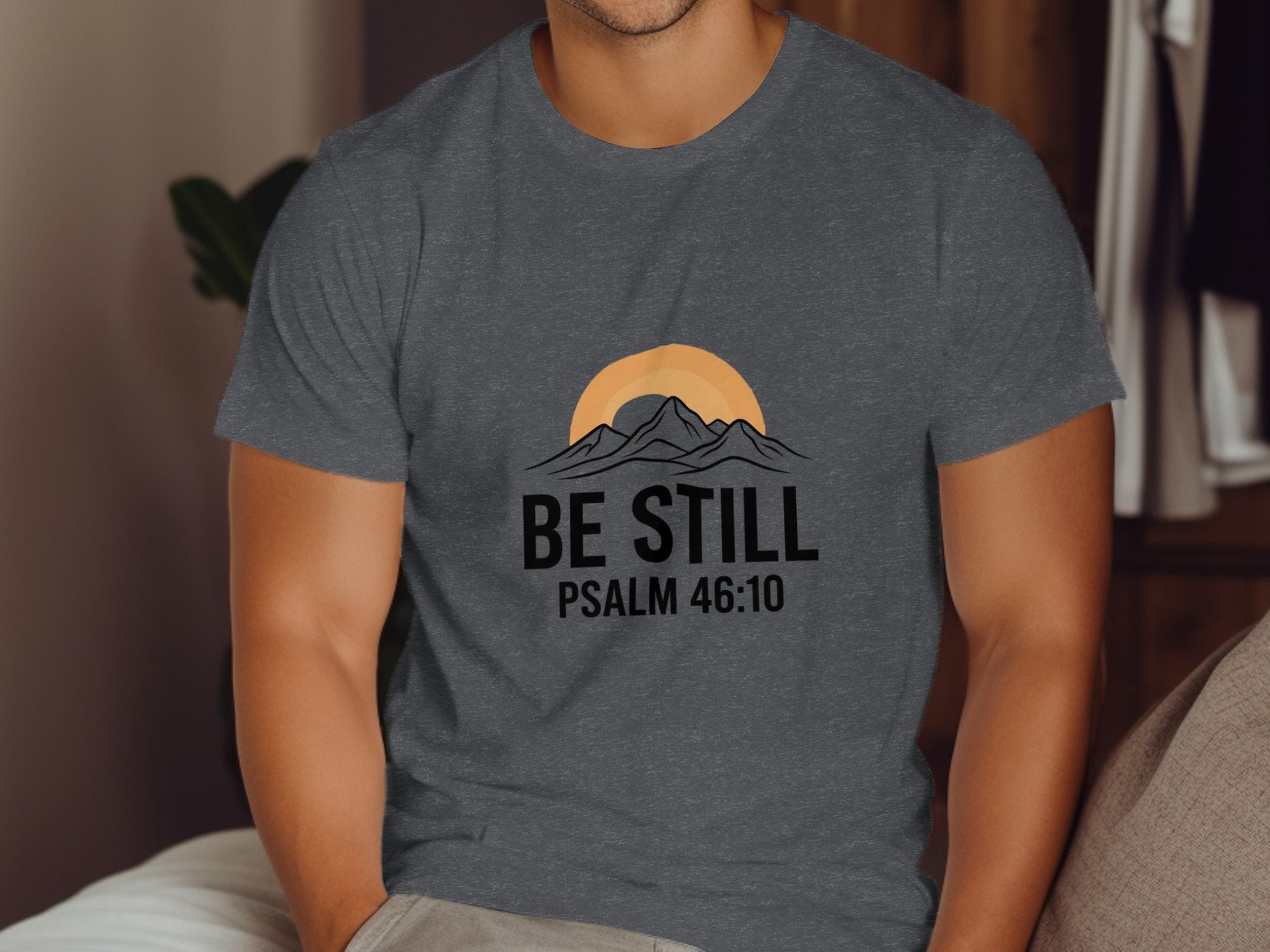 Dark grey t-shirt with "BE STILL PSALM 46:10" and mountain sunset graphic.