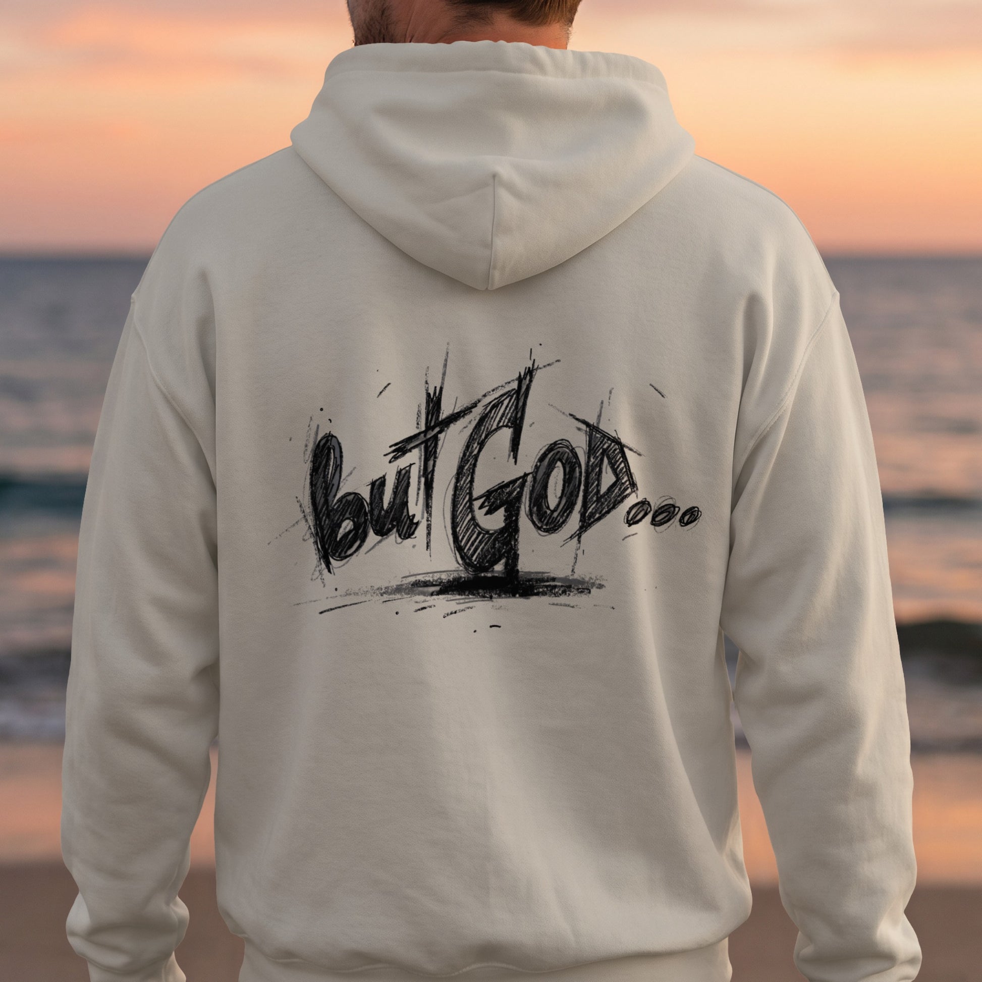 Cream hoodie with "but GOD..." text on the back, beach background.