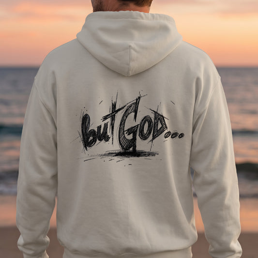 Cream hoodie with "but GOD..." text on the back, beach background.