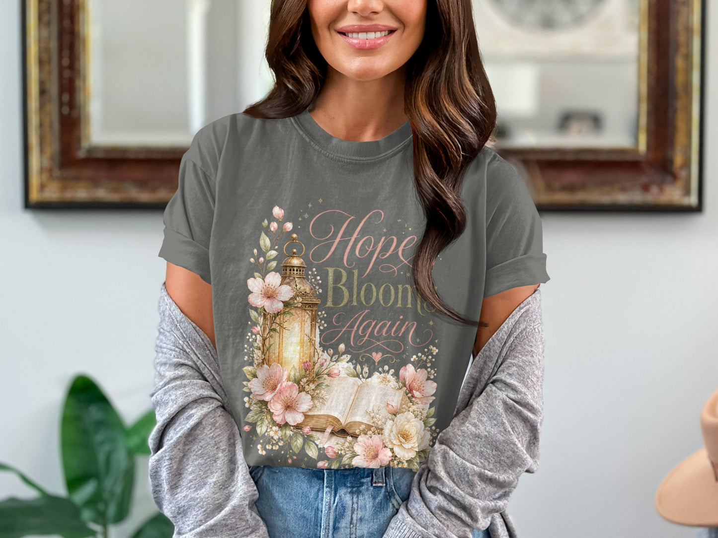 T-shirt with "Hope Blooms Again" text, antique lantern, open book, and floral watercolor art.