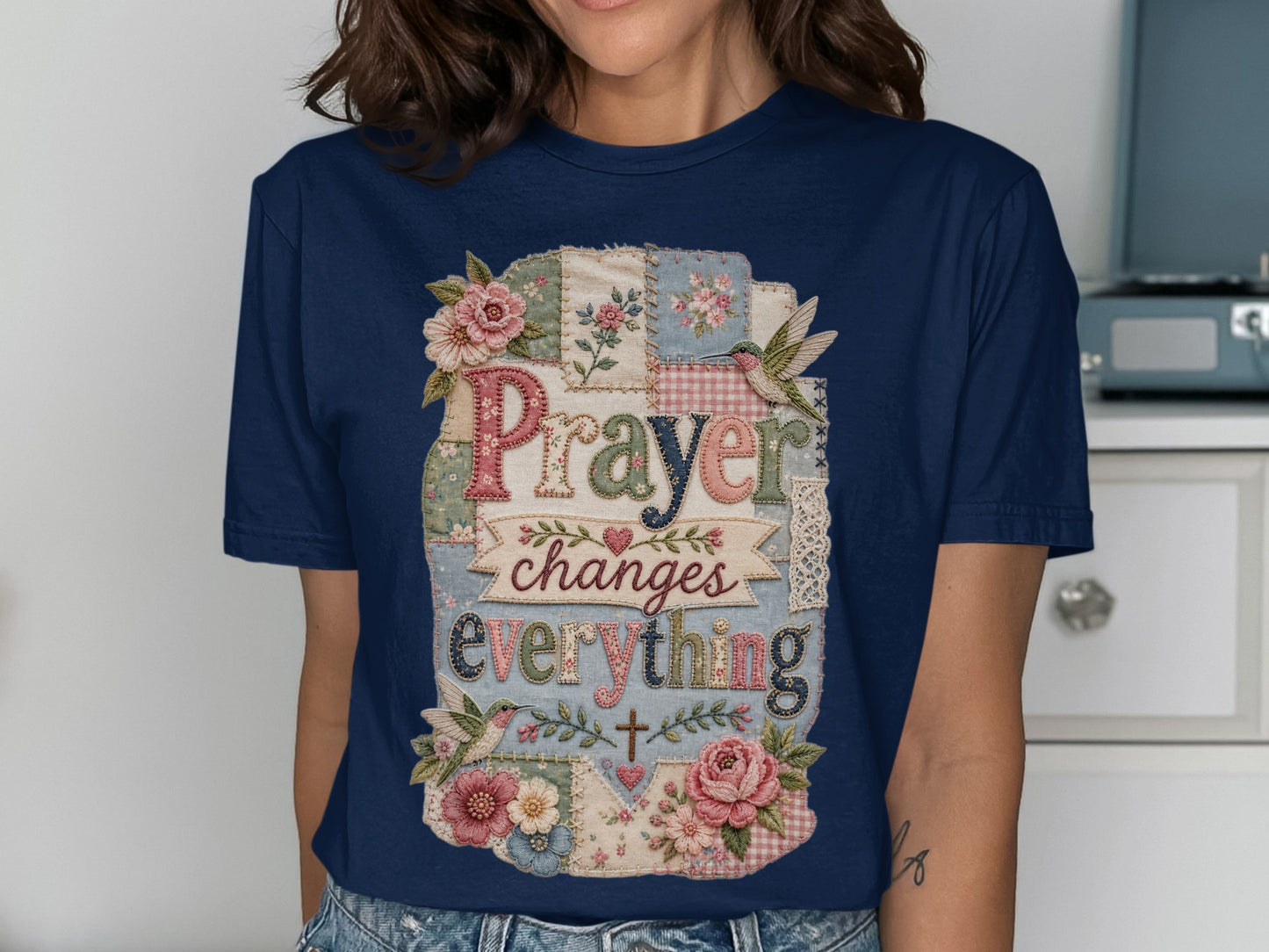 Navy t-shirt with "Prayer changes everything" in a patchwork design with flowers.