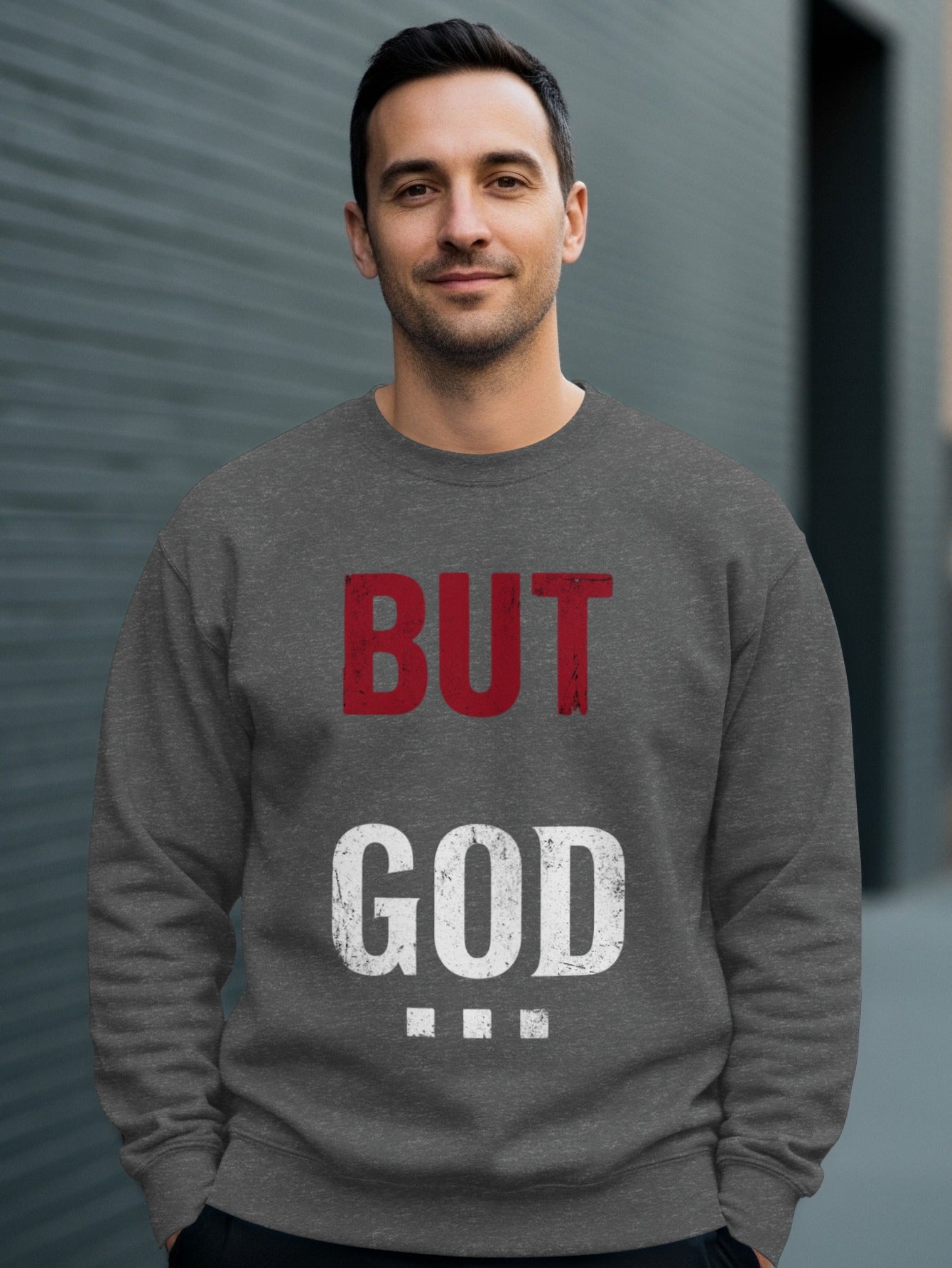 Man wearing gray sweatshirt with "BUT GOD" text.