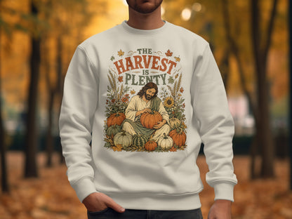 Jesus sits among pumpkins with "The Harvest Is Plenty" text.