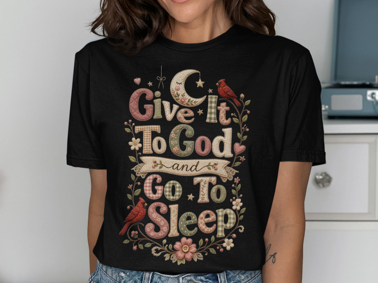 Black t-shirt with text "Give It To God and Go To Sleep" and floral accents.
