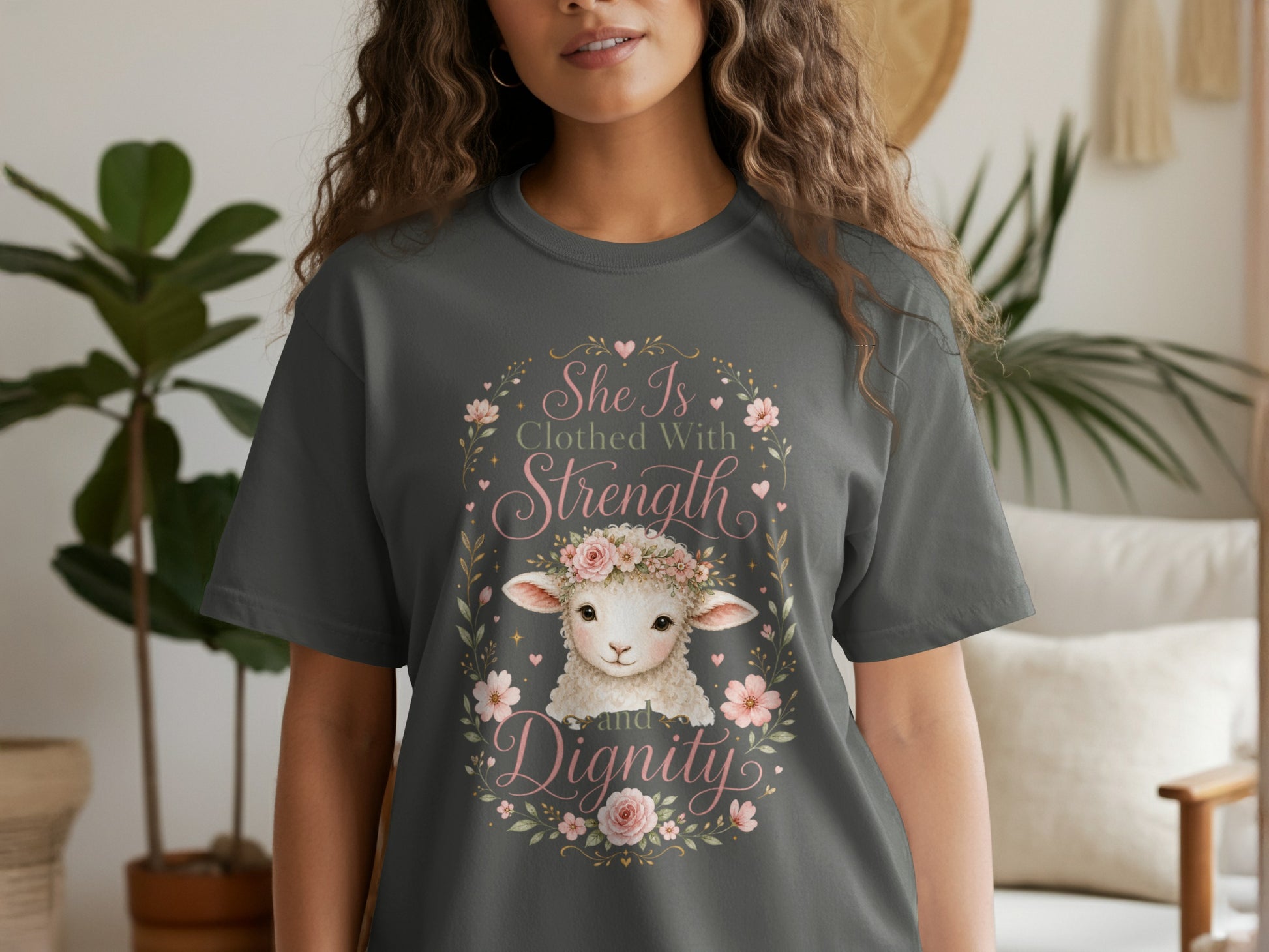 Dark grey t-shirt with a lamb, flowers, and the text "She Is Clothed With Strength and Dignity."