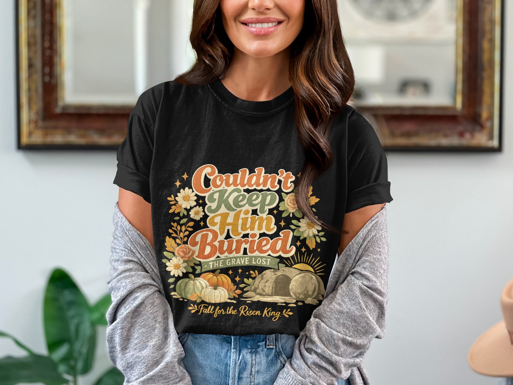 Black t-shirt with "Couldn't Keep Him Buried" text, tomb, pumpkins, and flowers.