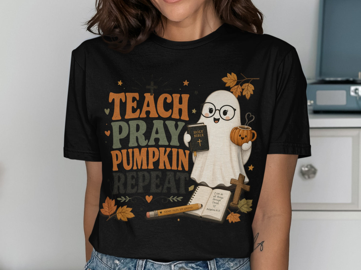 T-shirt graphic with ghost holding Bible and pumpkin mug, "TEACH PRAY PUMPKIN REPEAT" text.