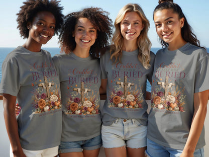 Four women wear gray t-shirts with a graphic of a cross, flowers, and text.