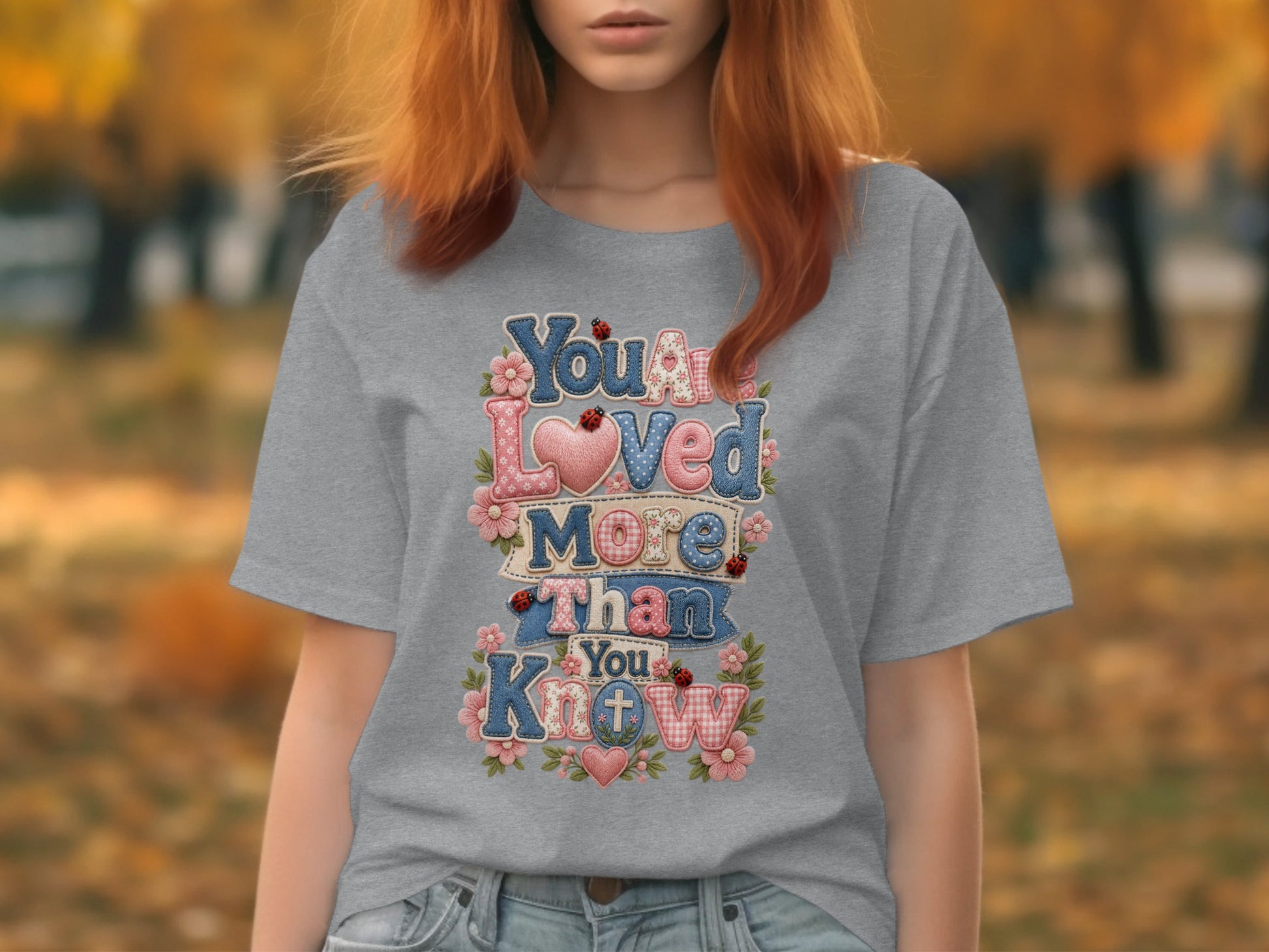 Grey t-shirt with "You are loved more than you know" text and floral accents.