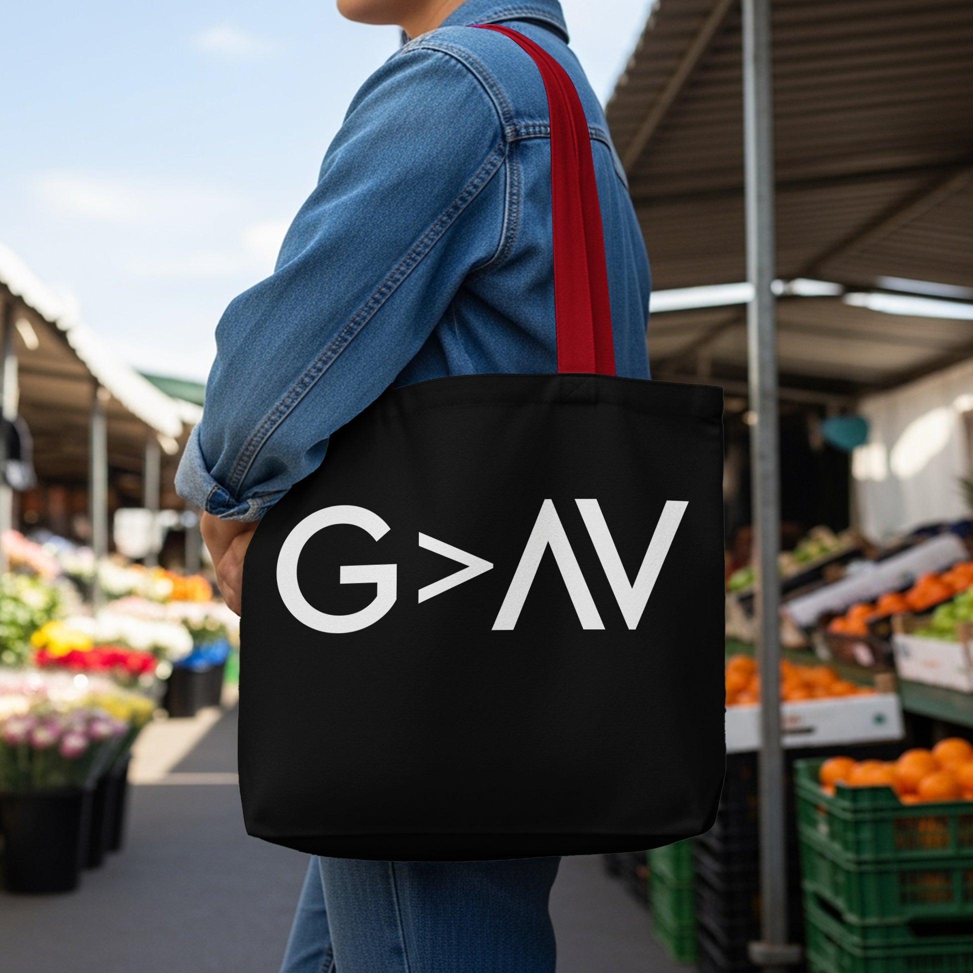 Black tote bag with red straps and white "G > AV" text in the foreground.