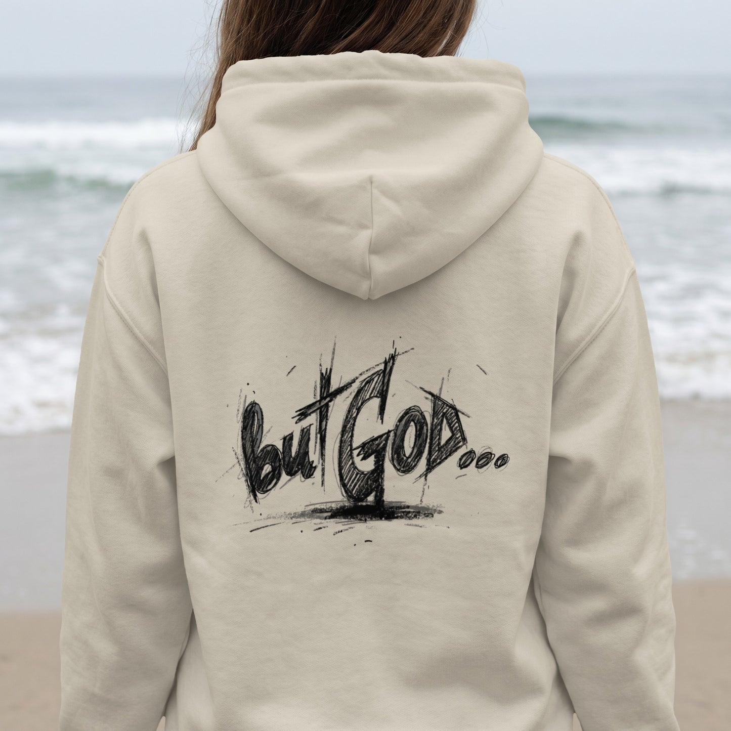 Back of beige hoodie with "But God..." scribbled text.
