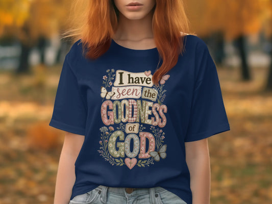 Navy t-shirt with "I have seen the goodness of God" text and floral accents.