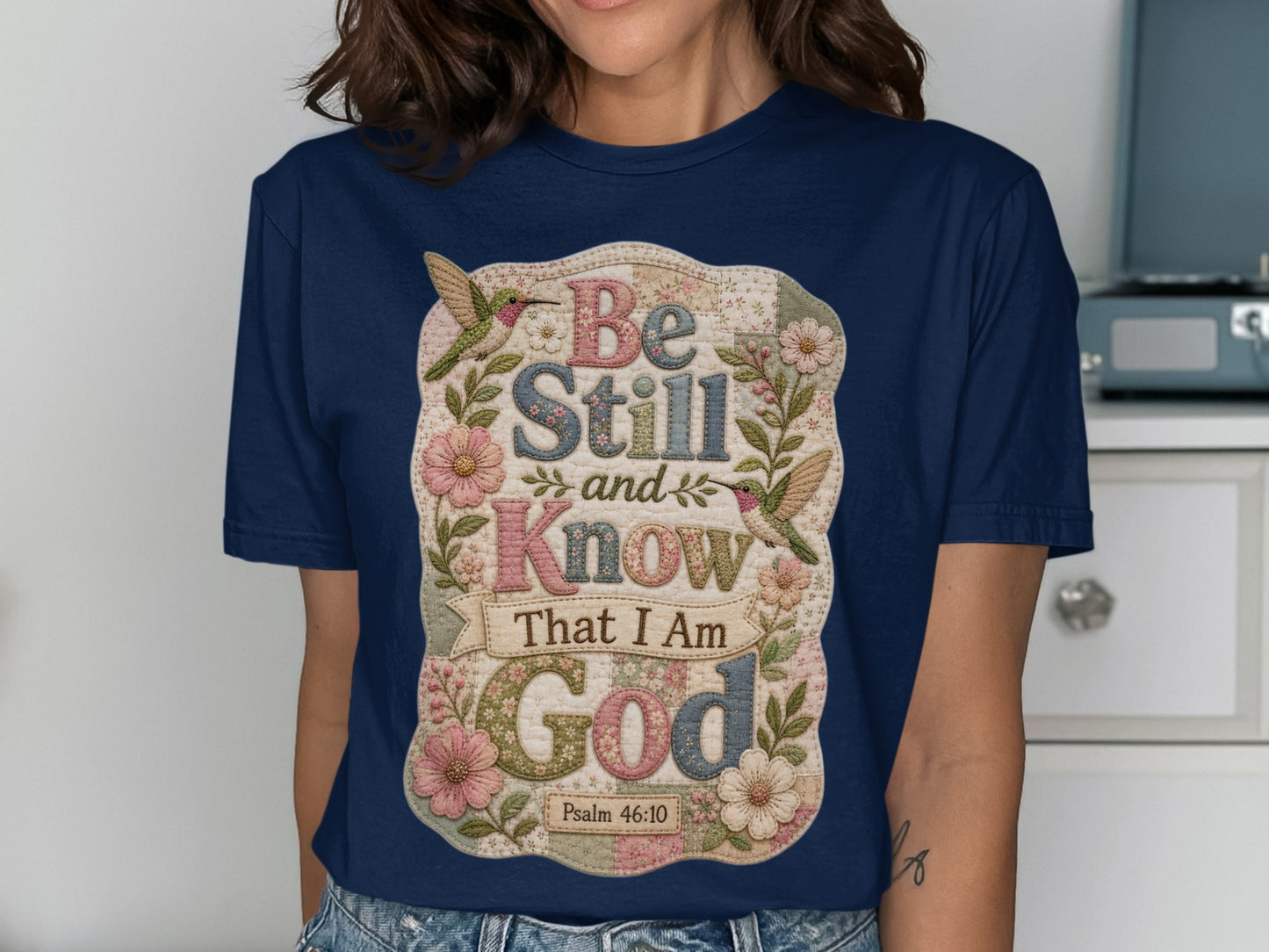 Navy t-shirt with floral and hummingbird design and "Be Still and Know That I Am God Psalm 46:10".