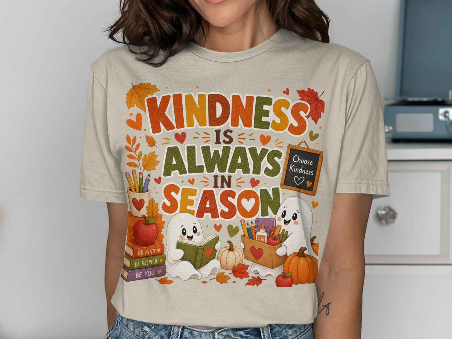 T-shirt graphic: "Kindness is Always in Season" with cute ghosts, books, and fall leaves.