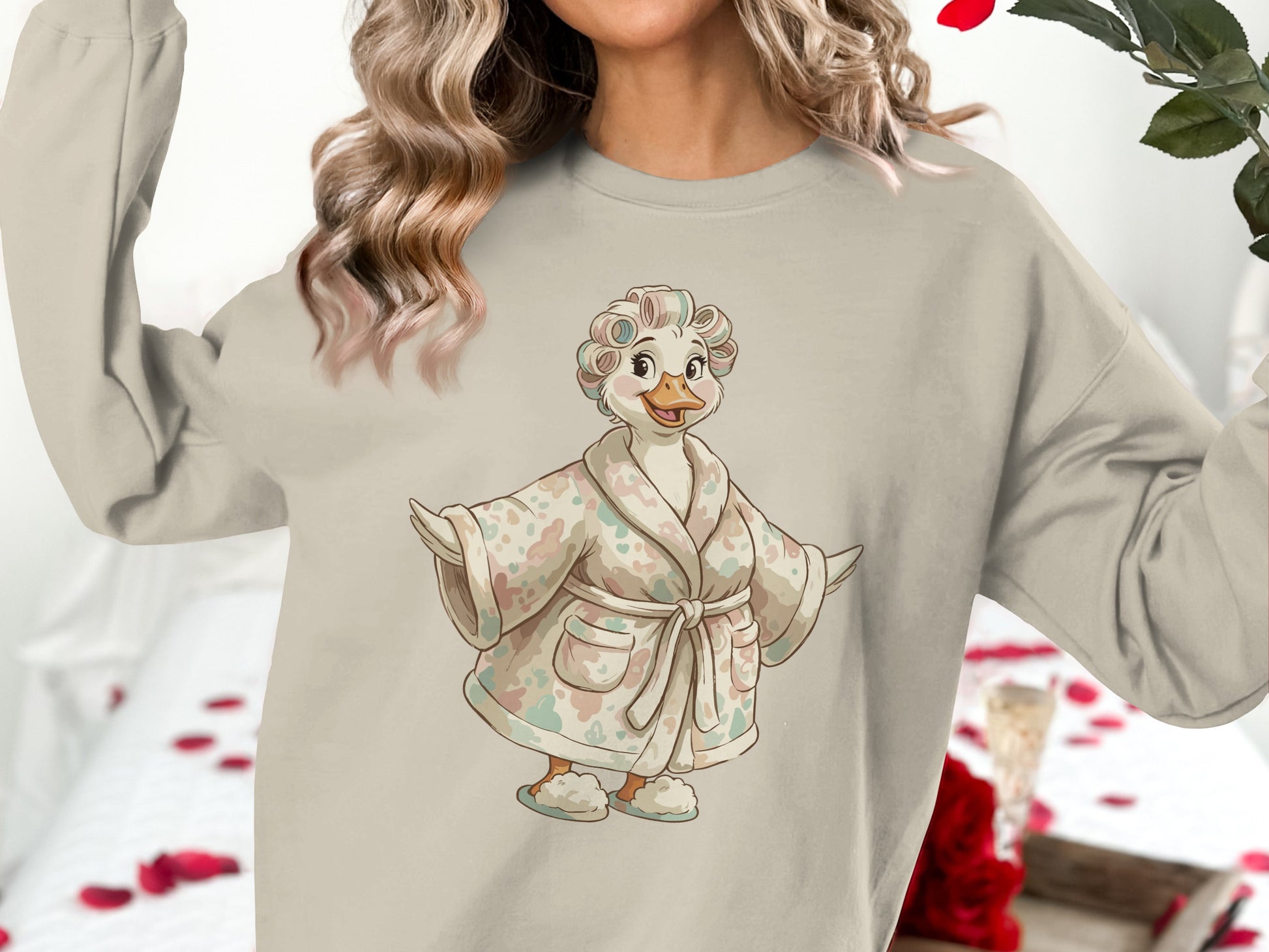Cream sweatshirt with a cartoon duck wearing a robe and curlers.