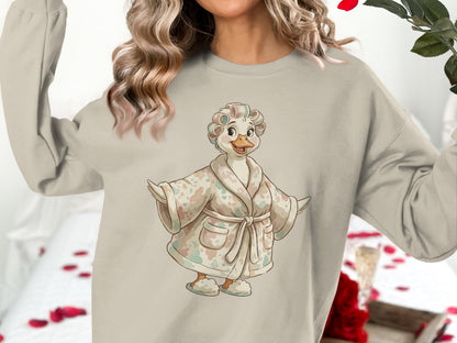 Cream sweatshirt with a cartoon duck wearing a robe and curlers.