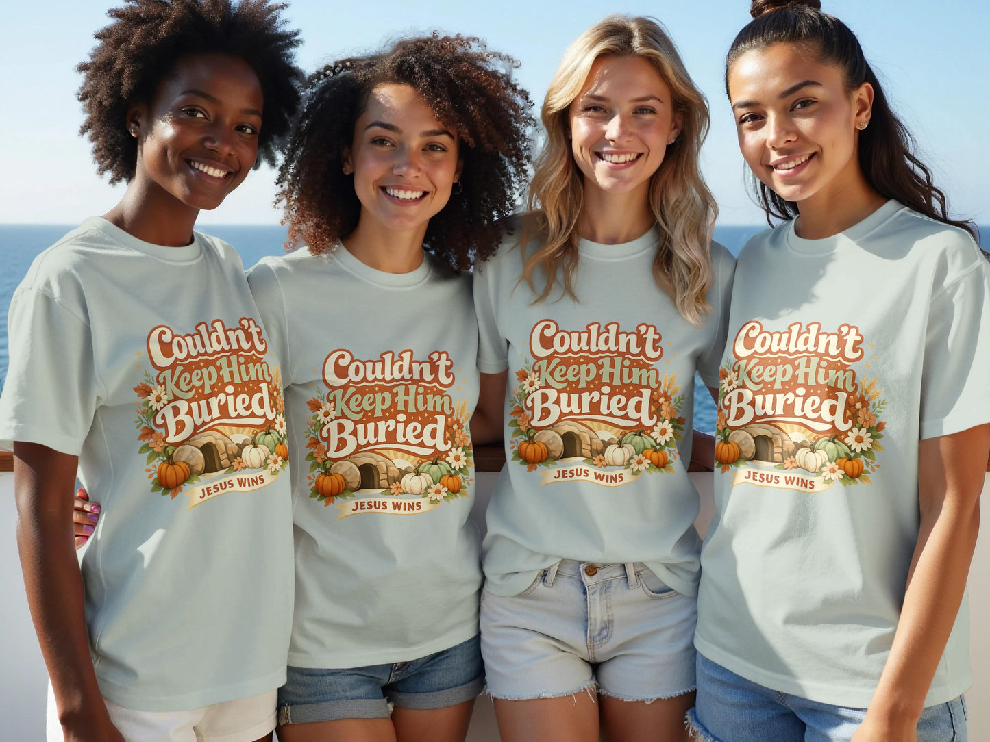 Four women wear light blue t-shirts with "Couldn't Keep Him Buried JESUS WINS" text and fall graphics.