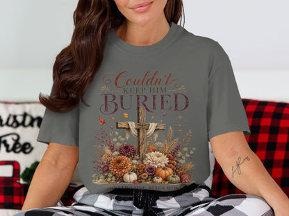 Gray t-shirt with a wooden cross, flowers, pumpkins, and text "Couldn't Keep Him Buried".