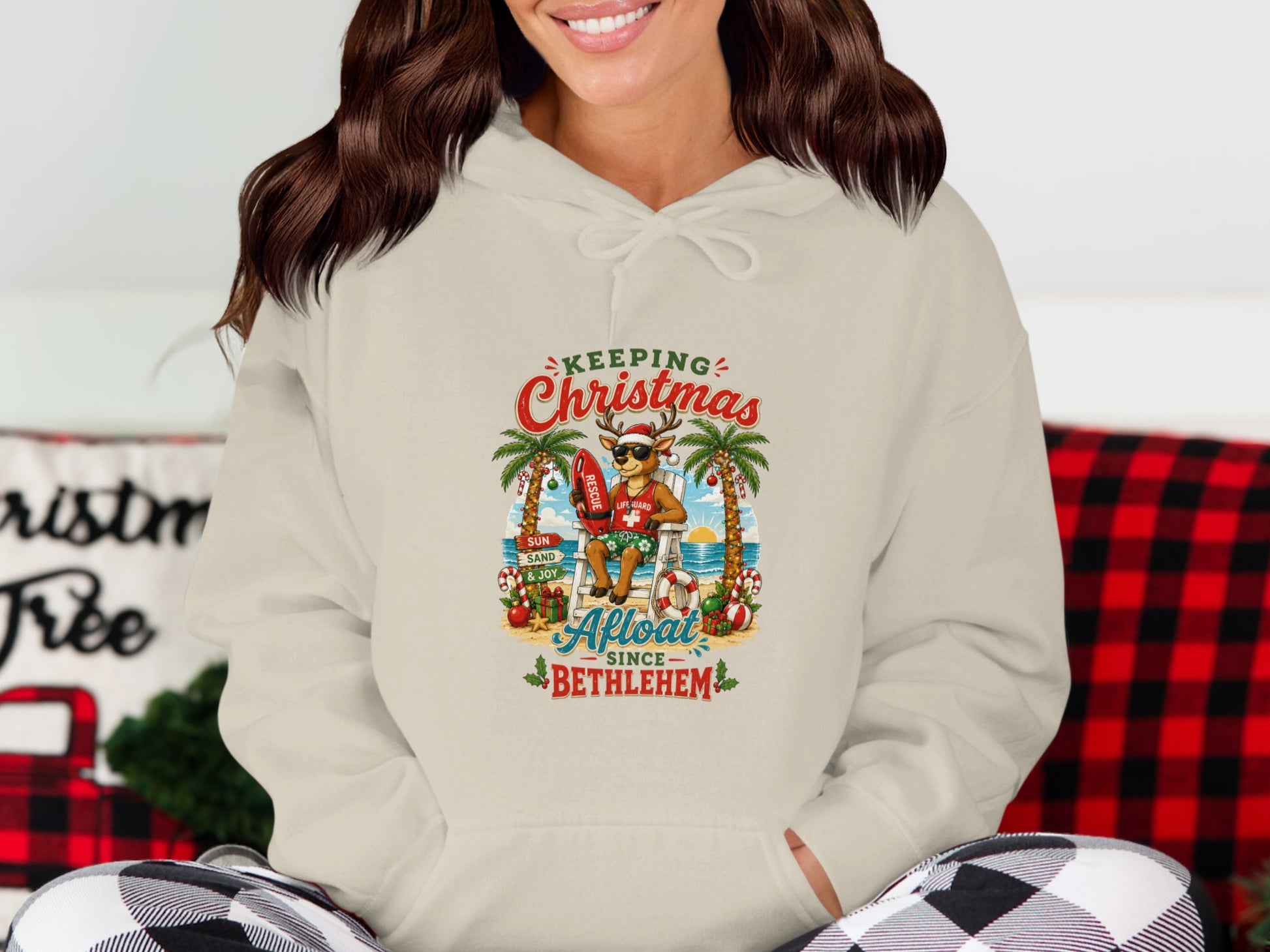 Christmas hoodie graphic featuring a lifeguard reindeer on a beach.