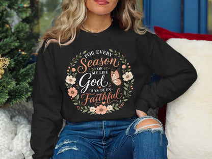 Black sweatshirt with floral wreath and "For every season of my life God has been faithful" text.