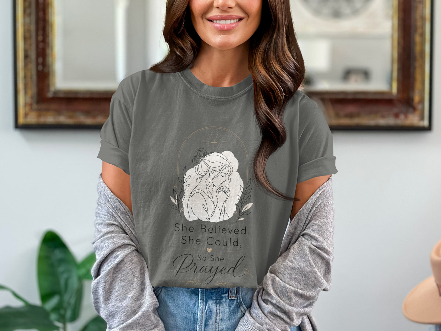 Gray t-shirt with line art of praying woman and text "She believed she could, so she prayed."