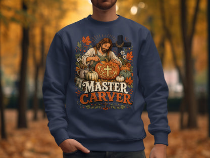 Jesus carving a pumpkin with "Master Carver" text on a dark blue sweatshirt.