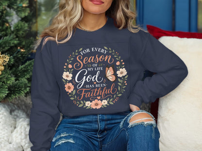Dark blue sweatshirt with floral wreath and "For Every Season of My Life God Has Been Faithful" text.