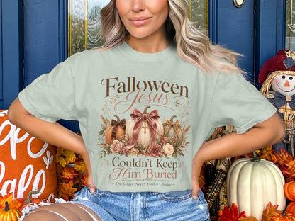 Light green t-shirt with "Falloween Jesus Couldn't Keep Him Buried" text and pumpkins.