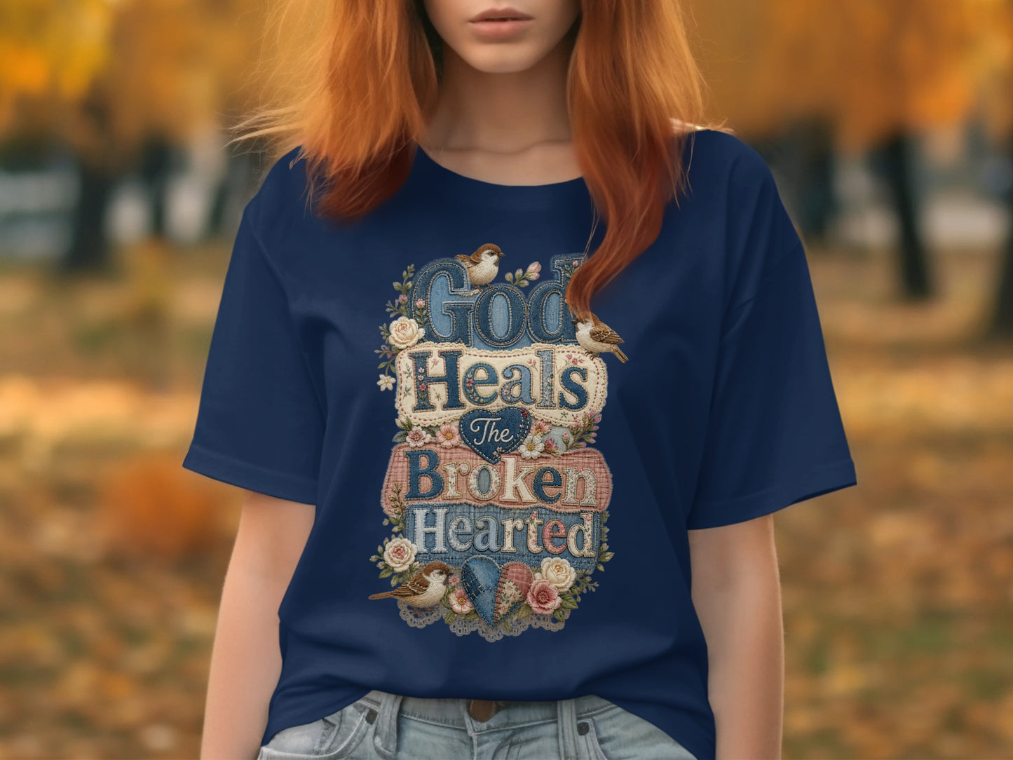 Navy t-shirt with "God Heals The Broken Hearted" text and floral accents.