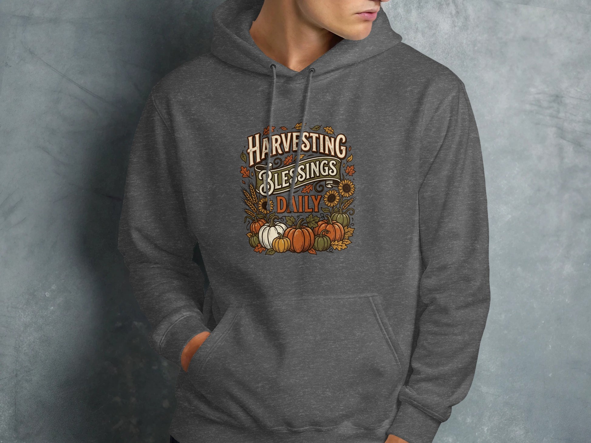 Dark gray hoodie with "Harvesting Blessings Daily" autumn graphic.