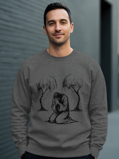 Man wearing a grey crewneck sweatshirt with a sketch of a kneeling figure between two trees.