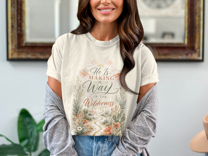 Light cream t-shirt with a desert path, wildflowers, and text "He Is Making a Way In The Wilderness".