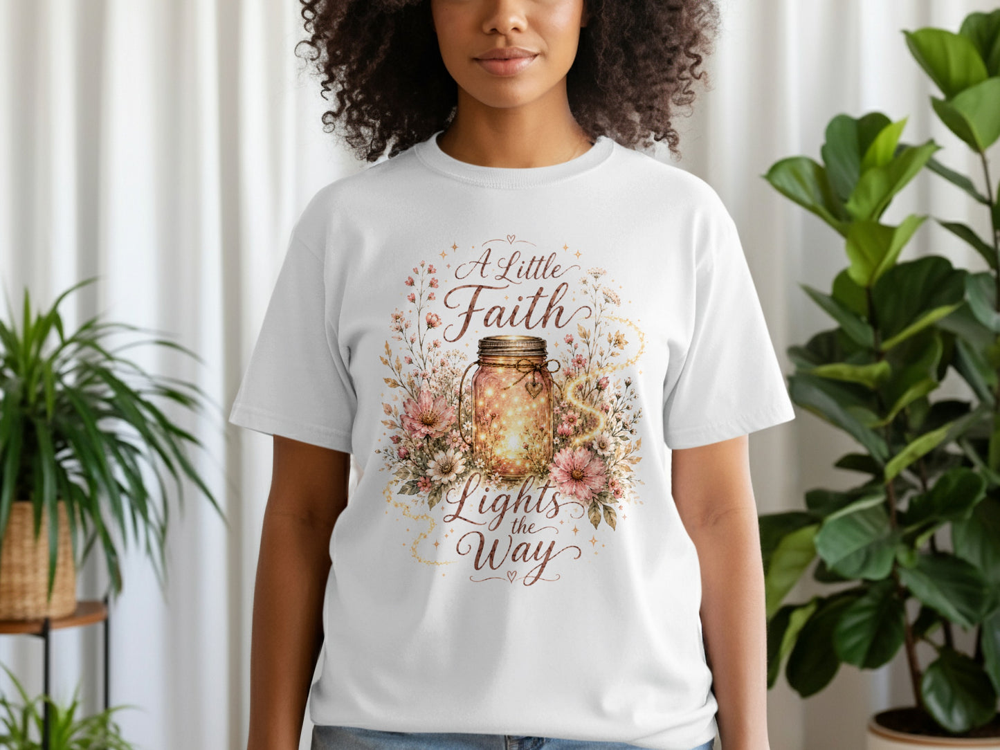 White t-shirt with "A Little Faith Lights the Way" text and jar graphic.