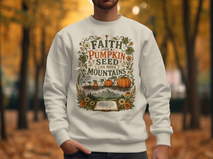 Cream sweatshirt with "Faith Like a Pumpkin Seed Can Move Mountains" text and autumn harvest design.