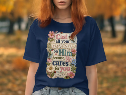 Navy t-shirt with embroidered text: "Cast all your anxiety on Him because He cares for you 1 Peter 5:7".