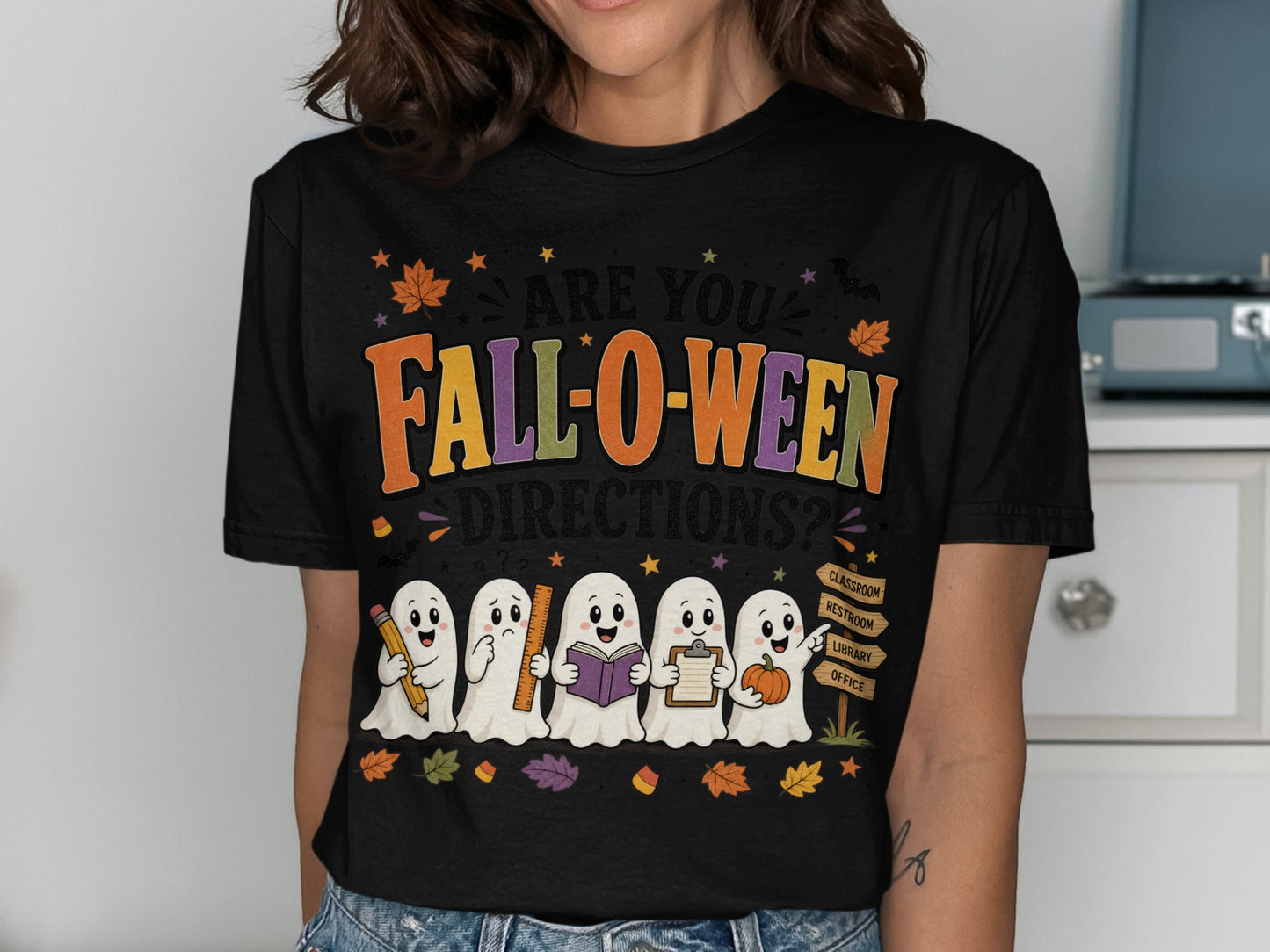 Cute ghosts are on a black t-shirt with "Fall-o-ween Directions?" text.