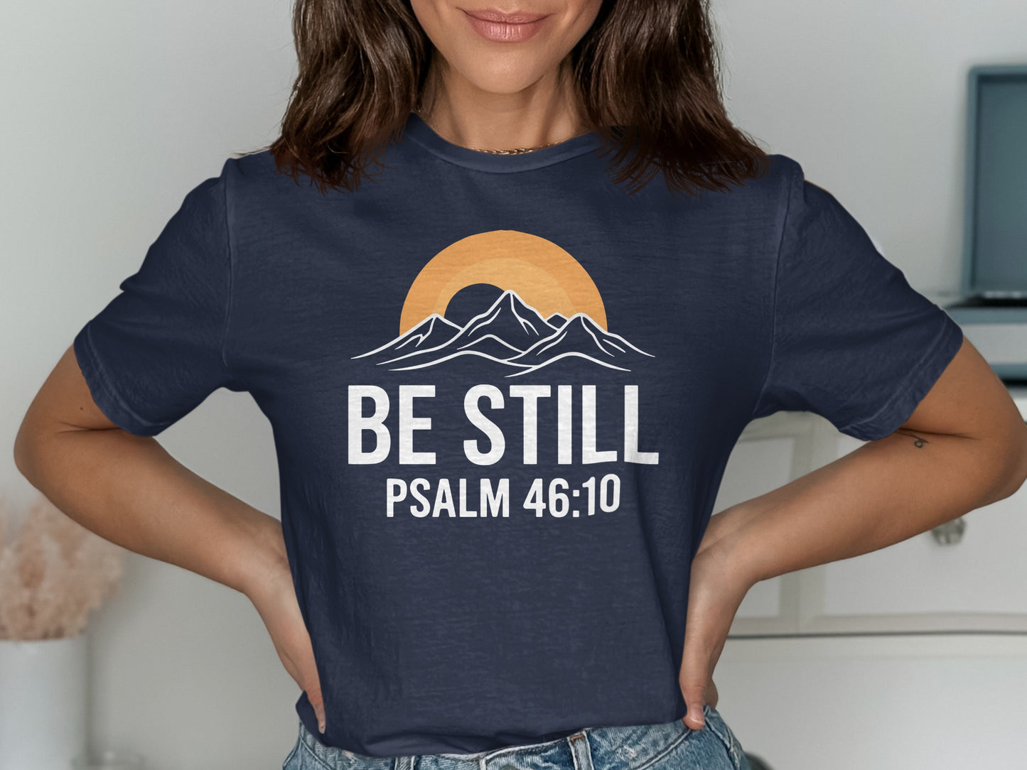 Navy t-shirt with "BE STILL PSALM 46:10" and mountain sunset graphic.