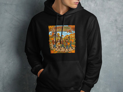Black hoodie with a graphic of people walking through a pumpkin patch.