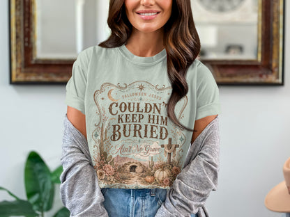 Light blue t-shirt with "Falloween Jesus Couldn't Keep Him Buried Ain't No Grave" graphic.