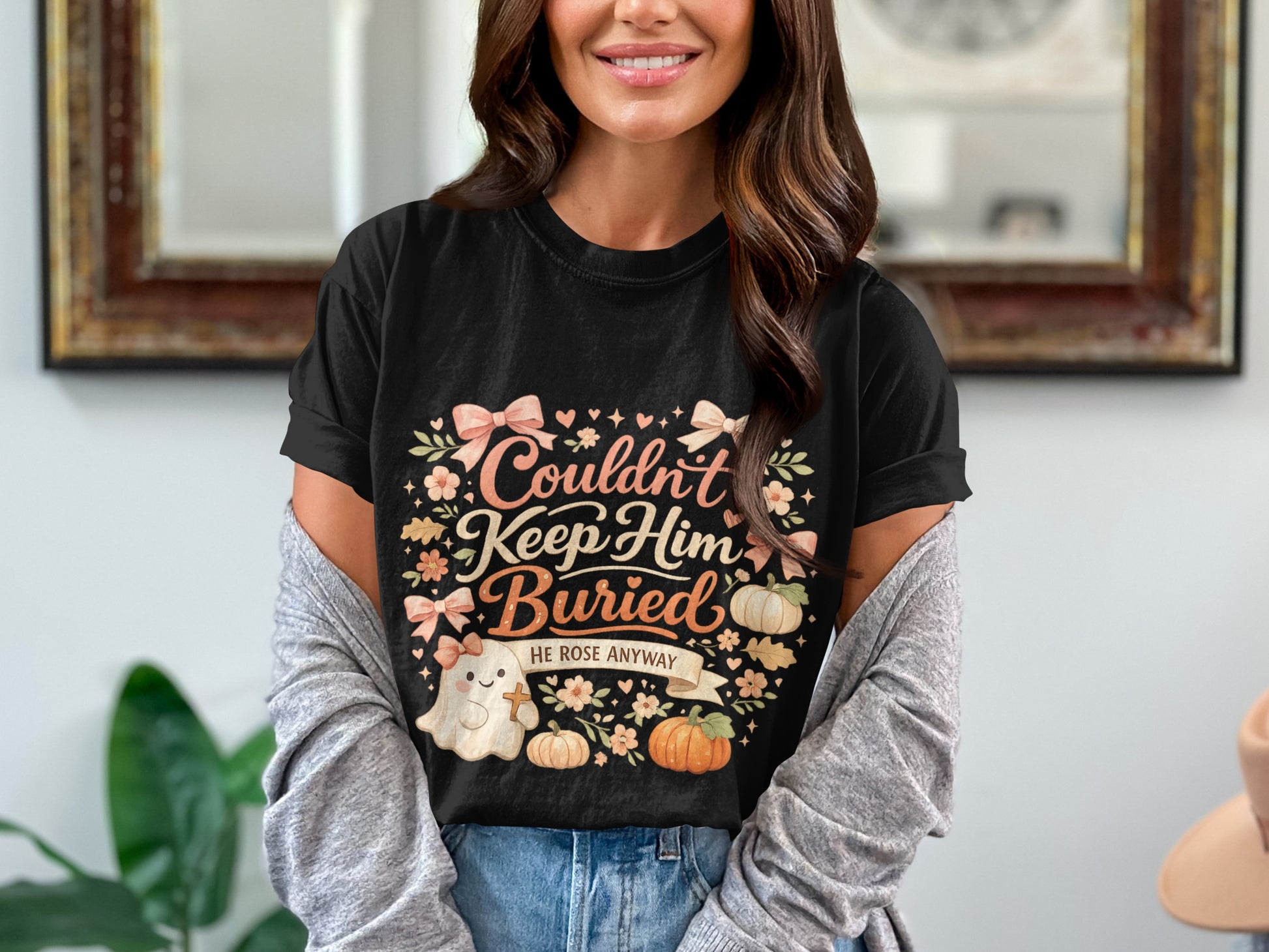 Black t-shirt with ghost and pumpkins graphic reading "Couldn't Keep Him Buried HE ROSE ANYWAY."