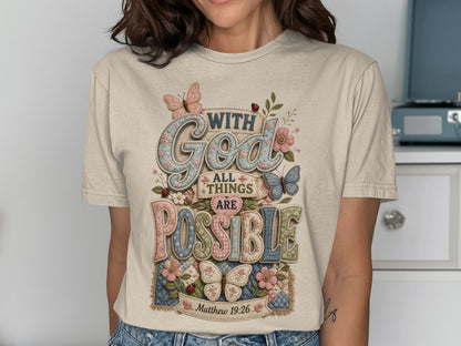 T-shirt with "God All Things Are Possible" text and floral butterfly design.